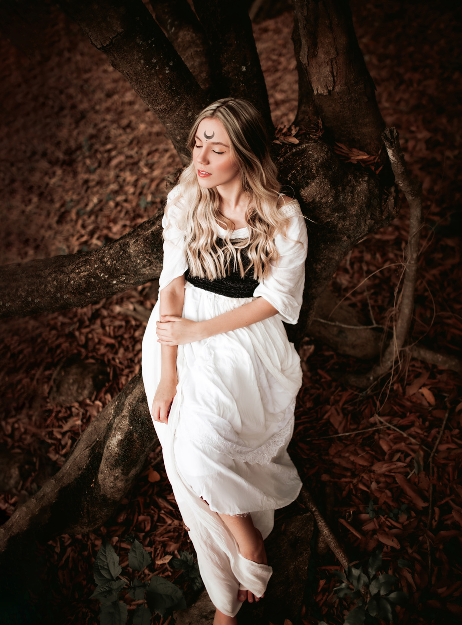 Woman in White Dress Lying Down on Tree Trunks