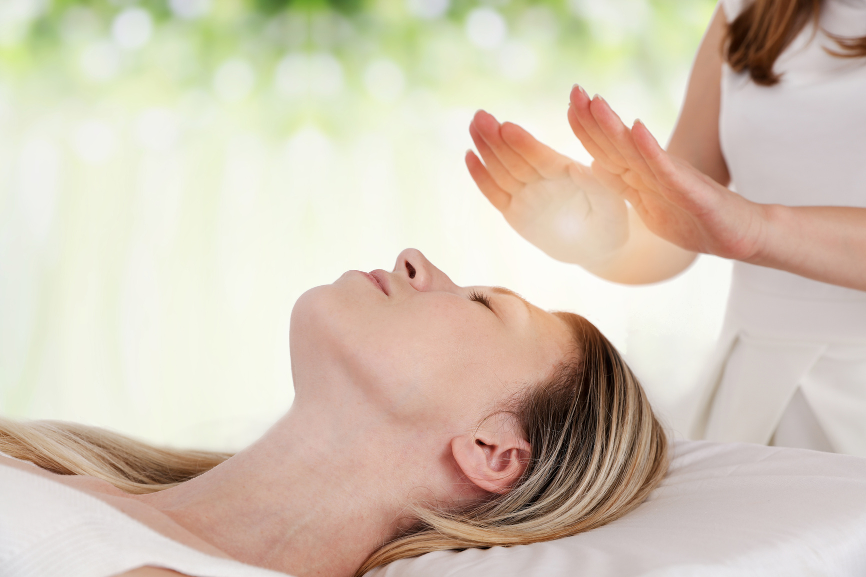 Woman having reiki healing treatment , alternative medicine concept.